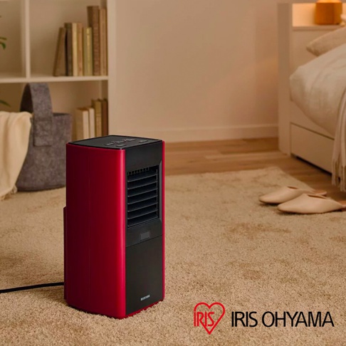 紅色與黑色的大範圍人感陶瓷電暖器，置於臥室地毯上，機身側面印有 IRIS OHYAMA 標誌。