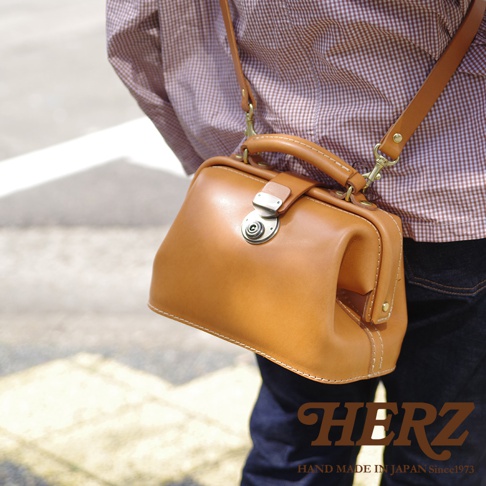 職人手作皮革方型迷你醫生包，採用經典焦糖棕皮革，配有銀色旋轉鎖扣和可拆卸肩帶，展現復古風格。