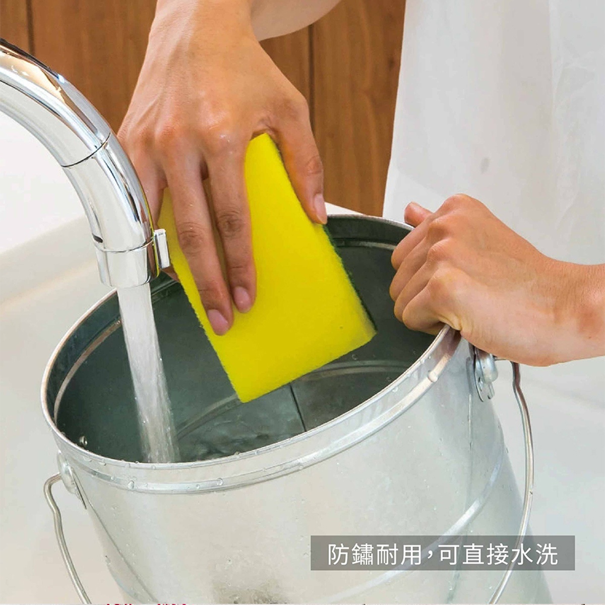 模式B： 一人手持黃色海綿在水龍頭下沖洗，將海綿置於一個銀色金屬水桶中，水桶內已有部分水。