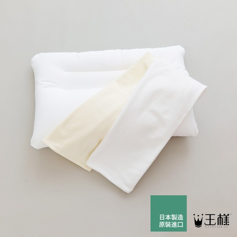 白色頸椎枕，附有兩個枕套，一個為淡黃色，另一個為白色，皆為柔軟材質。