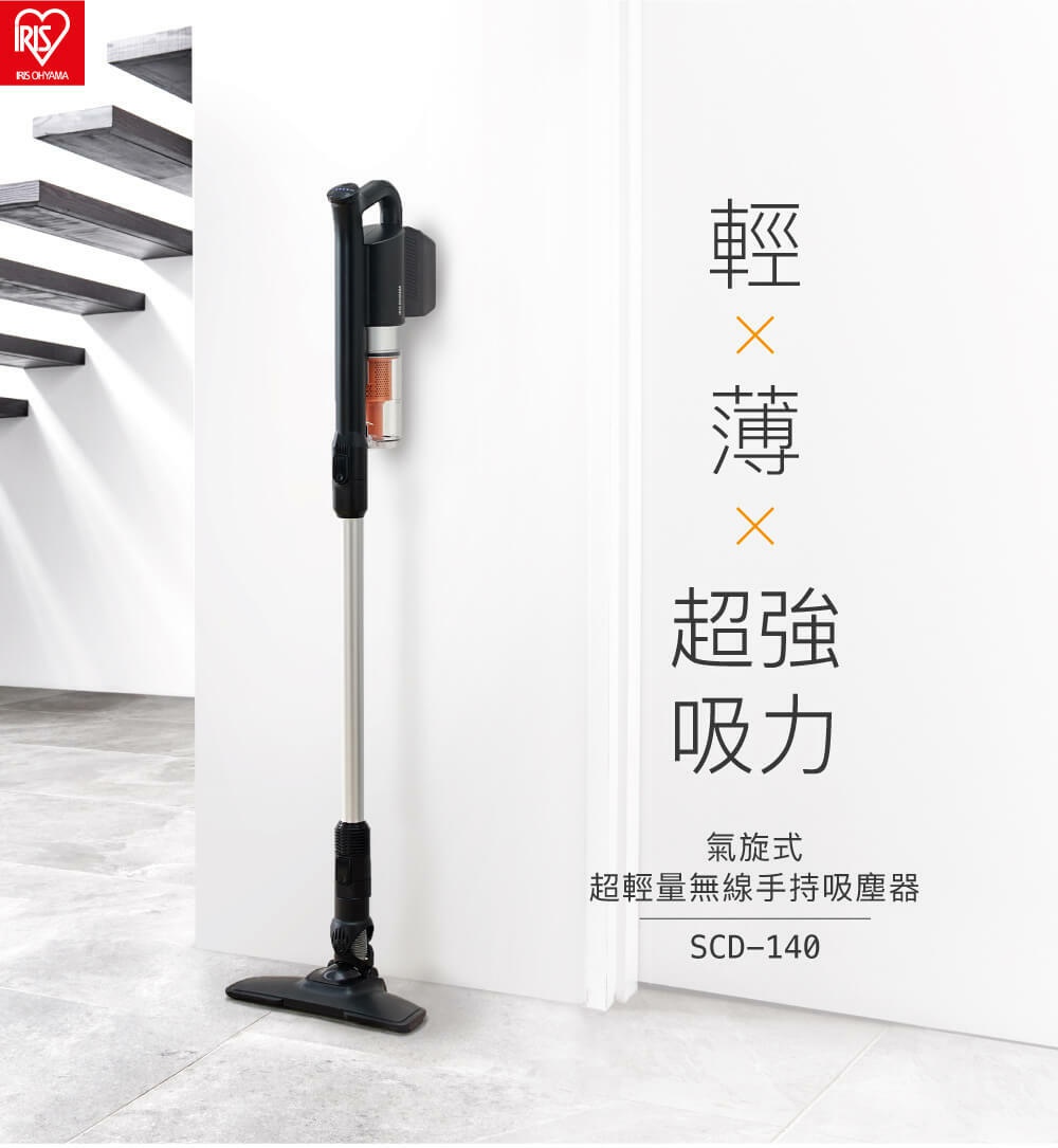 一支黑色、銀色金屬桿、帶有透明集塵筒的氣旋式超輕量無線手持吸塵器，垂直靠牆放置，底部有黑色吸頭。