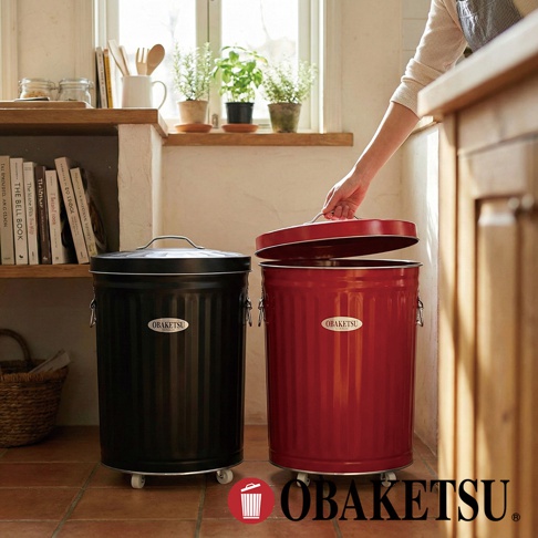 OBAKETSU 品牌復古風格的紅色與黑色附輪垃圾桶，擺放在廚房窗台旁，其中紅色垃圾桶的蓋子正由一位女士開啟