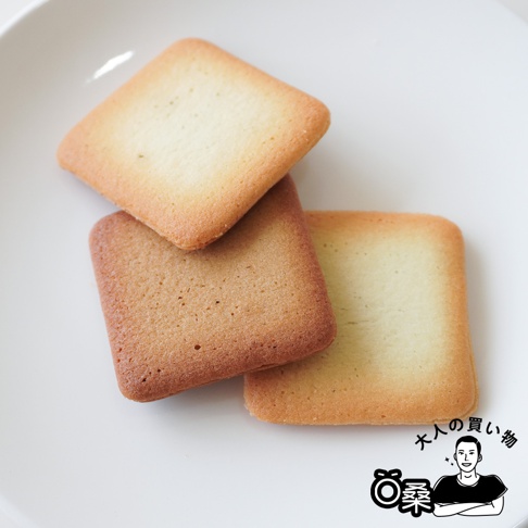 一盤裝著三塊方形餅乾，其中兩塊疊在一起，一塊放在旁邊。