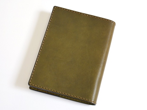 橄欖綠色皮革厚革書套，以深色縫線手工縫製，簡約設計。