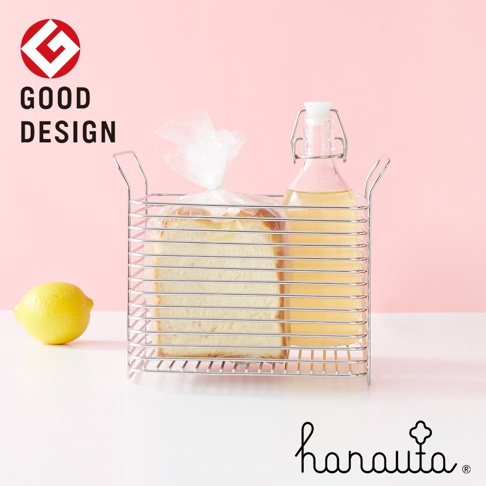 不鏽鋼深型收納籃，內有裝在塑膠袋中的吐司和一瓶黃色液體的玻璃瓶，左側有一顆黃色檸檬。