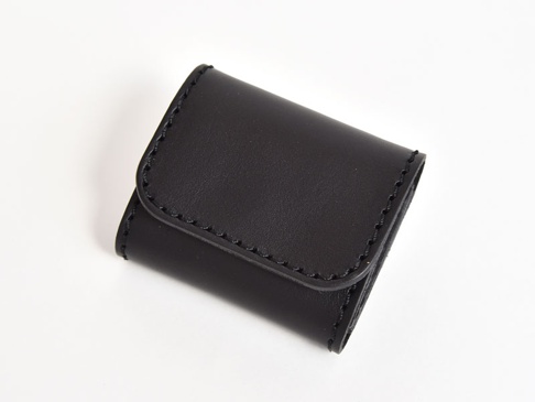 黑色皮革雙折收納零錢包，車縫線明顯，材質為皮革。