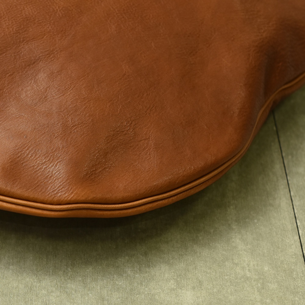 職人手作皮革Organ單肩半月包，採用柔軟的咖啡色皮革製成，包身呈現自然的弧度，邊緣有細緻的縫線，質感溫潤。