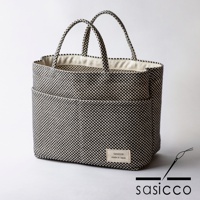 三河木綿刺子織多口袋托特包，黑色與白色棋盤格紋，織紋清晰，附有兩個外口袋和兩個提把，內襯為米白色棉質。