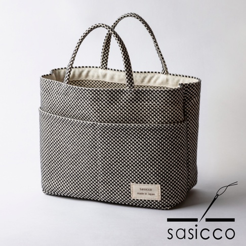 三河木綿刺子織多口袋托特包，黑色與白色棋盤格紋，織紋清晰，附有兩個外口袋和兩個提把，內襯為米白色棉質。