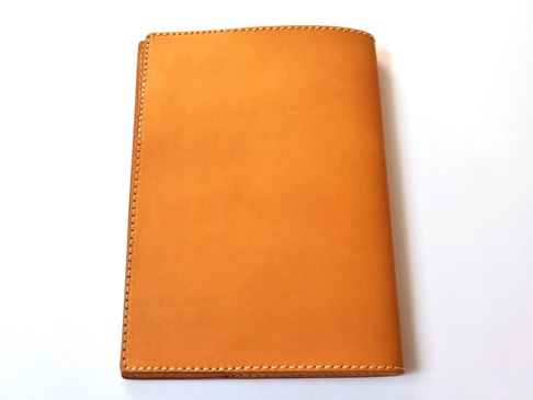 職人手作皮革A5筆記本書套，L尺寸，天然皮革材質，呈現溫潤的淺棕色調，邊緣以白色車縫線精緻勾勒。