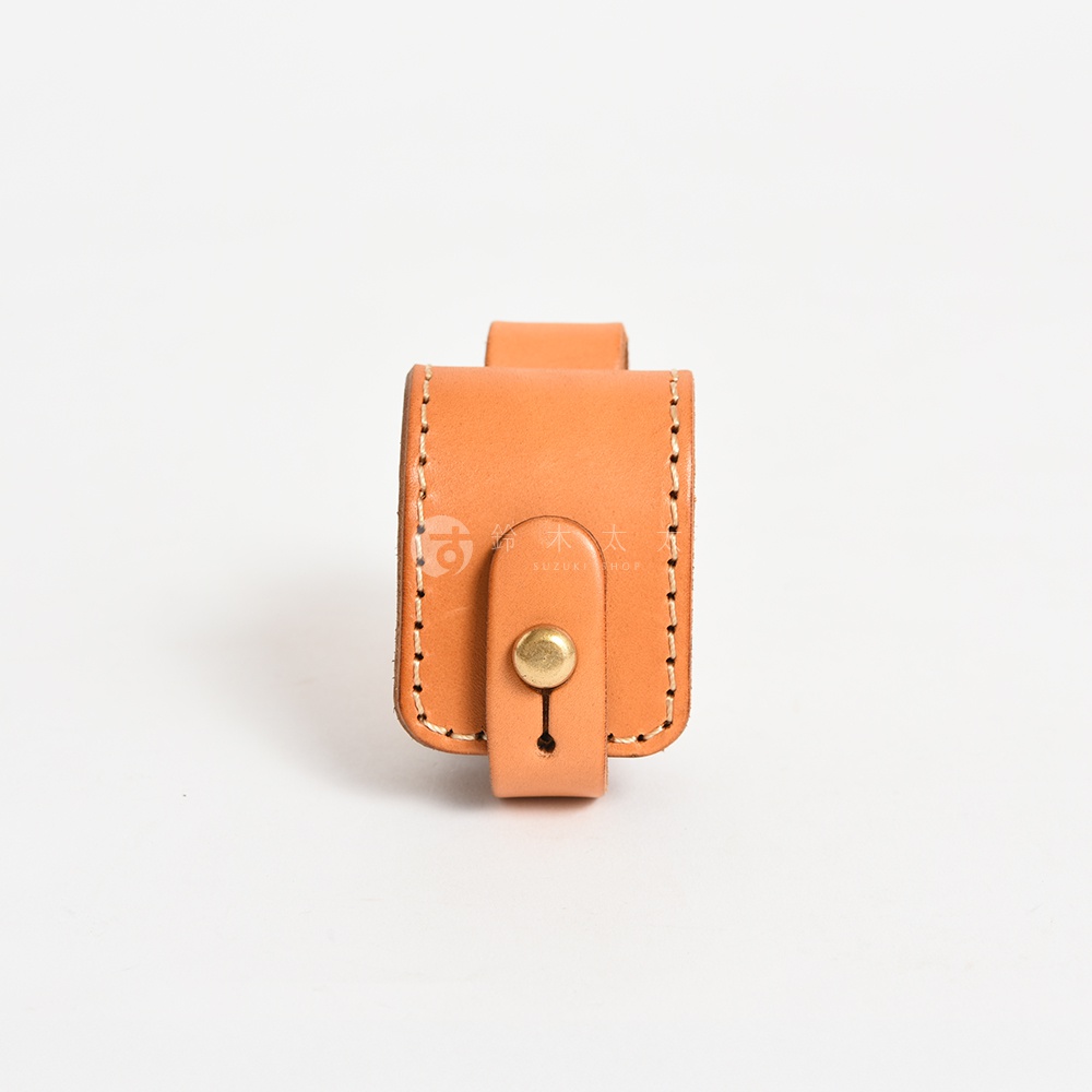 淺棕色皮革製作的原子釦式腰間小物收納包，有著精緻的手工車縫線，上方有可固定皮帶的環狀設計。