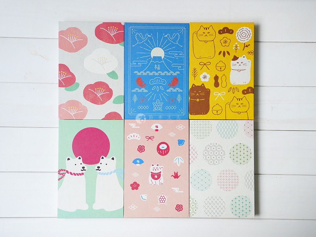 六款美濃和紙製成的御朱印帳，分別印有紅色山茶花、藍色日出風景、黃色招財貓、綠色背景的白色犬隻、粉色背景的招財貓與吉祥物、以及白色背景的各式幾何圖案。