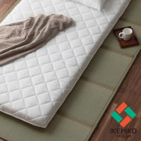 YUME 藺草組合式五折疊榻榻米睡墊，白色菱格紋填充物，鋪設在綠色藺草榻榻米墊上，一角有咖啡色蓋毯與白色馬克杯。