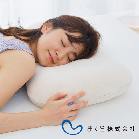 一位女性側臥在米白色、帶有拉鍊的調節枕上，枕套材質為棉質。