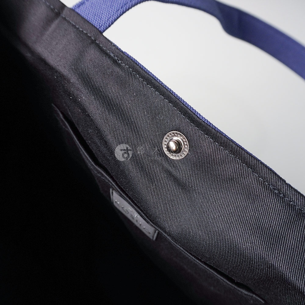 京都職人手作ougi棉帆布扇形托特包，近拍內裡細節，黑色帆布內襯，附有銀色金屬按扣，以及深藍色織帶提把。