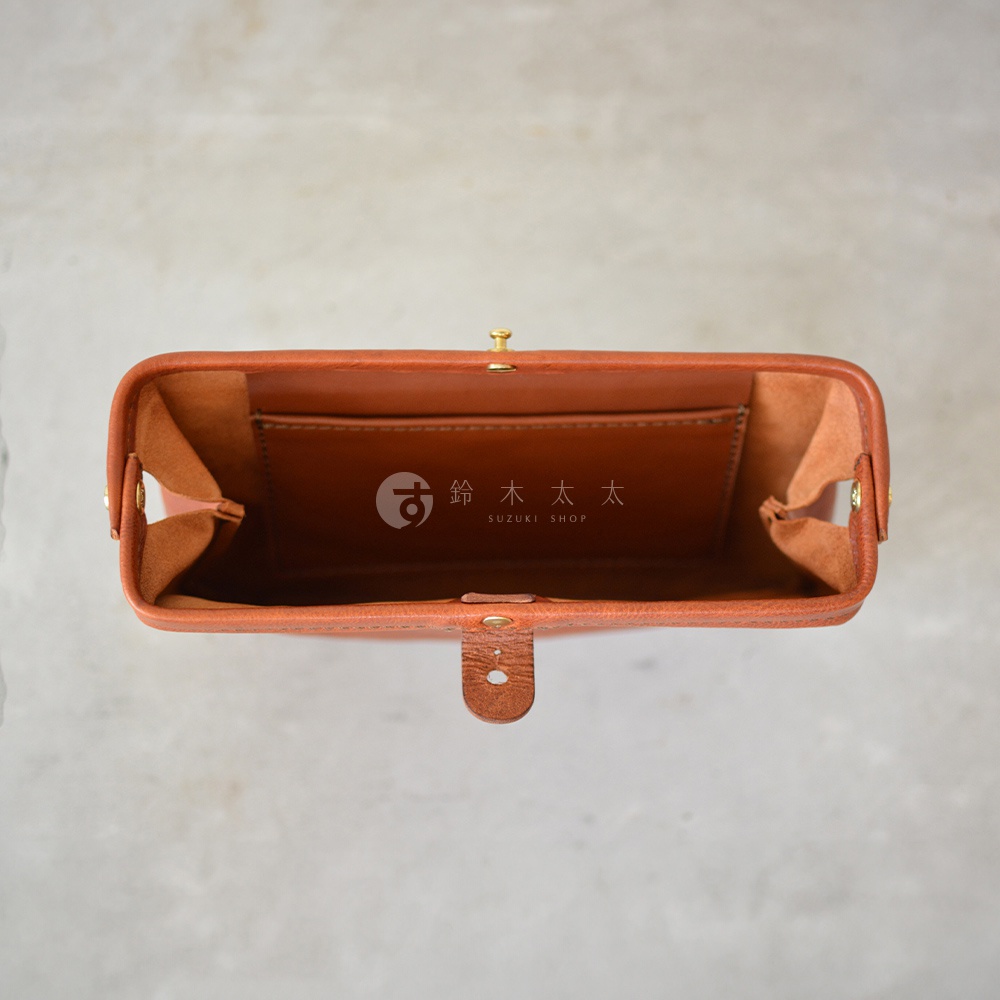 職人手作皮革Organ手拿包，焦糖棕色，皮革材質，可見內部隔層與金屬開合。