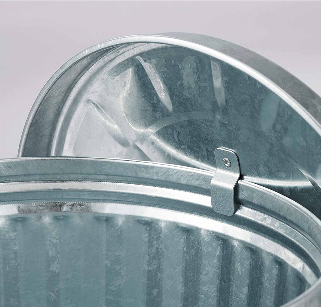 一個閃亮的鍍鋅金屬垃圾桶的特寫鏡頭，顯示了垃圾桶的邊緣和部分蓋子。