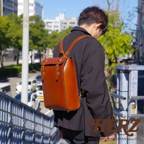 職人手作皮革後背包 R-31 (厚實版)，以厚實的棕色皮革製成，設計簡約，配有金屬釦和可調式皮革背帶。