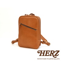 一個長方型的棕色皮革後背包，有拉鍊主袋和一個斜向拉鍊前袋，配有可調式皮革肩帶。