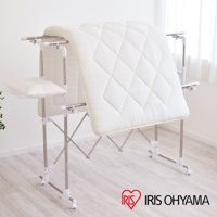 銀色金屬和白色塑膠材質的伸縮曬衣架，架上掛著一件白色菱格紋棉被，側面有一個白色枕頭。