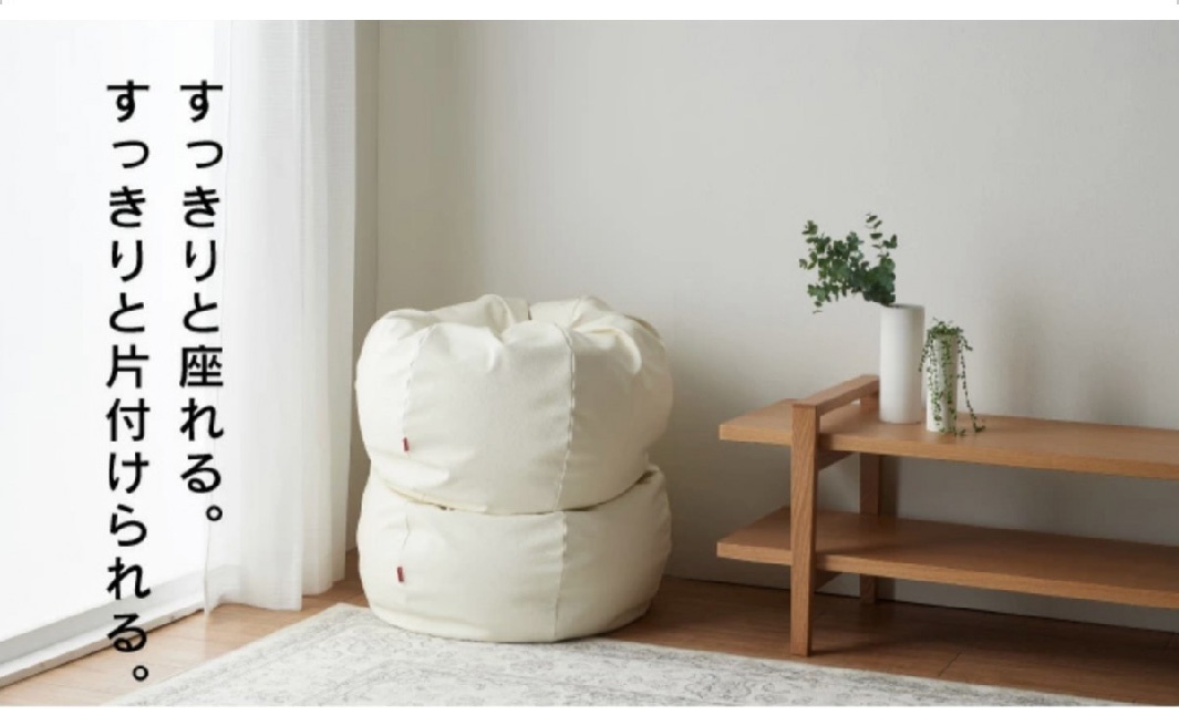 兩個堆疊的米白色懶骨頭沙發，皮革材質，圓潤飽滿，角落有紅色小標籤。