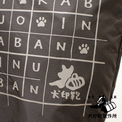 深灰色環保折疊收納購物袋，印有白色網格、字母、腳印圖案及犬印標誌。