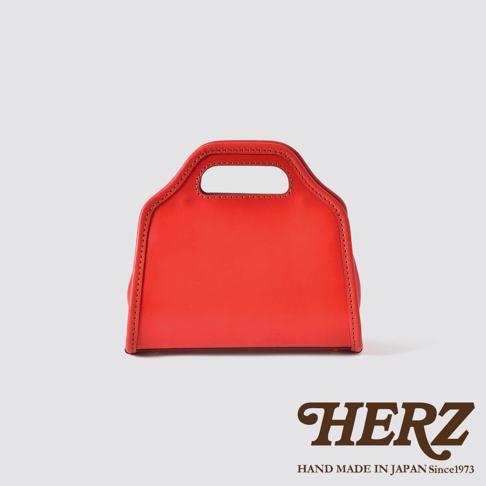 鮮紅色皮革手袋，經典拱型設計，雙提把，側面車縫線明顯，簡約時尚。