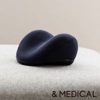 深藍色肩頸按摩紓壓枕，採用網狀織物材質，造型符合人體工學，置於淺灰色布料表面。