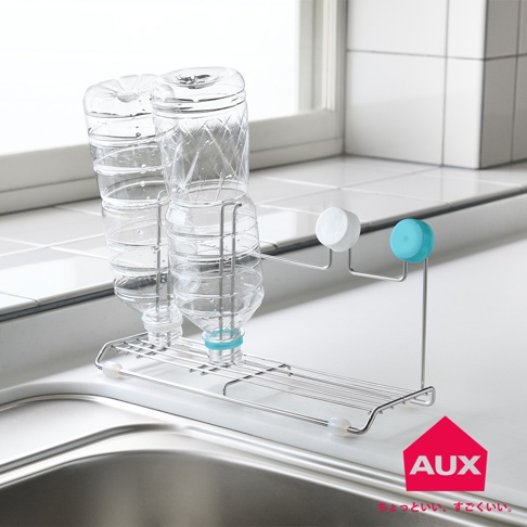 不鏽鋼瓶壺瀝水架，架上放置兩個已清空的透明塑膠瓶，瓶口朝下。瀝水架為金屬製，設有兩層支架，上面可放置瓶身，下方則有集水盤。架子旁有兩個不同顏色的瓶蓋，分別為白色和藍色。