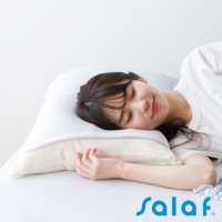 一名女性頭部舒適地枕在白色與米色雙層枕頭上，臉部朝右，閉眼微笑。枕套為白色，表面有細緻的織紋。