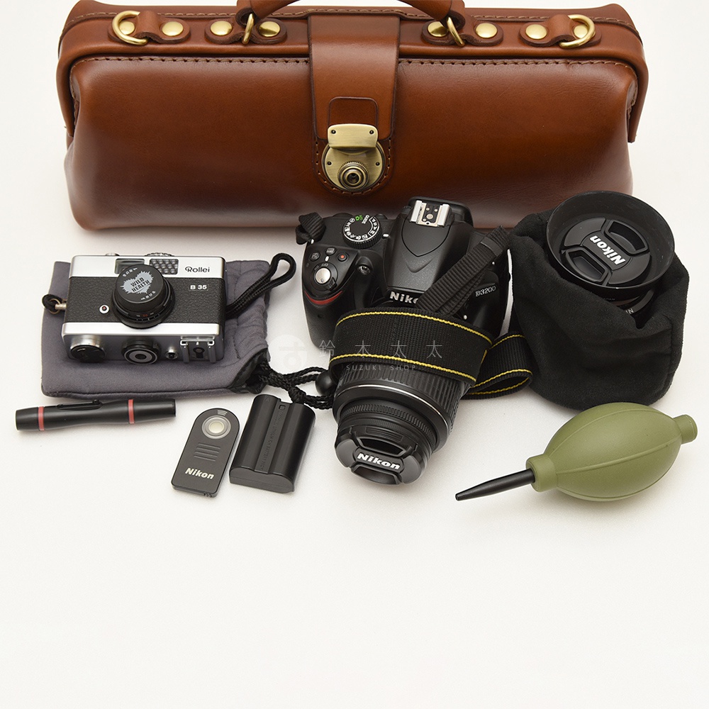 職人手作皮革橫長形杜勒斯單肩包，附有相機、鏡頭、鏡頭蓋、清潔器、電池和遙控器。