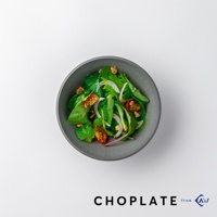 CHOPLATE BOWL 沙拉碗。一個圓形、深灰色的碗，裝有新鮮沙拉，包含綠葉蔬菜、小番茄、洋蔥圈和核桃。