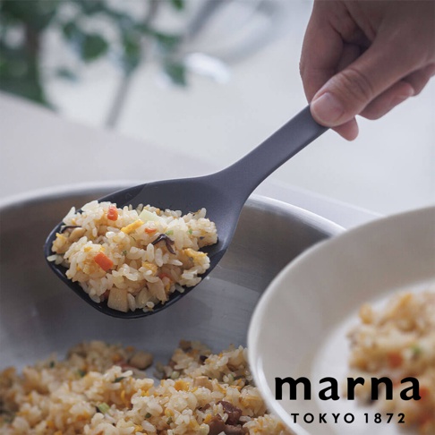 marna TOKYO 1872 品牌字樣旁，一隻手正拿著一隻黑色矽膠飯勺，飯勺中盛有炒飯，飯勺下方有一個銀色鍋子，鍋中也有炒飯，右側有一個白色碗，碗中也有炒飯。