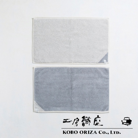 兩塊SUFFSUFF棉麻混紡快乾浴墊，上為淺灰色，下為中灰色，皆帶有白色滾邊，質地柔軟。