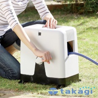 白色塑膠製的室外澆花灑水組，配有黑色底座和滾輪。藍色水管從機器側面捲起，一位女士正在操作手柄。