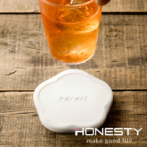 白色花型珪藻土矽膠杯墊，表面印有 karari 字樣，下方有 HONESTY Logo。