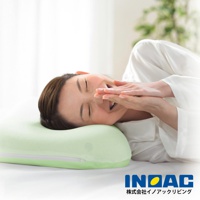 淺綠色記憶枕，表面有網狀織紋，帶有拉鍊。一位女士側臥，頭枕於枕頭上，雙手摀住嘴巴，閉眼微笑。