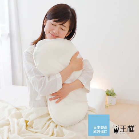 一名女子擁抱著白色蓬鬆的雲上枕，枕頭呈現圓潤的曲線，材質柔軟，帶有細緻的絨毛感。