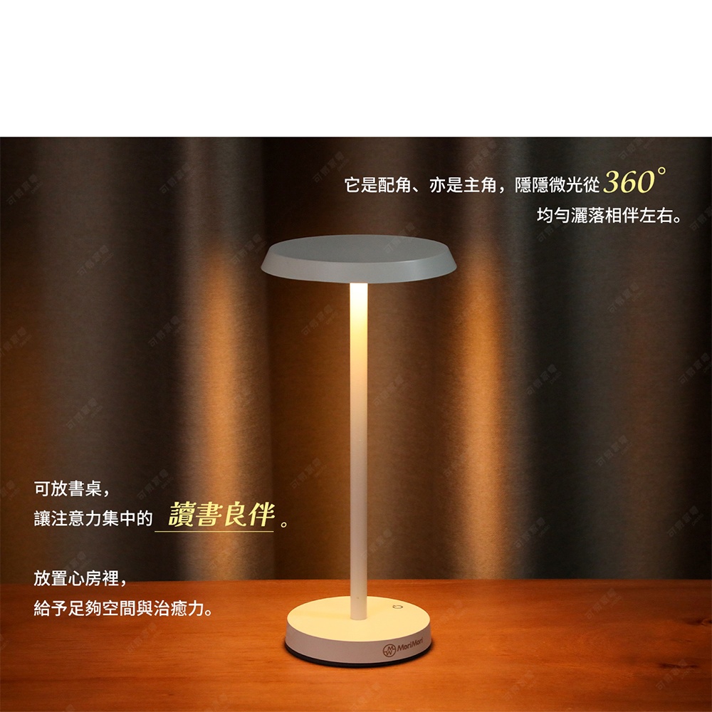 白色T型LED造型燈，頂部為圓形燈罩，燈柱纖細，底部為圓形底座，散發溫暖光線，照亮木質桌面與紋理背景。