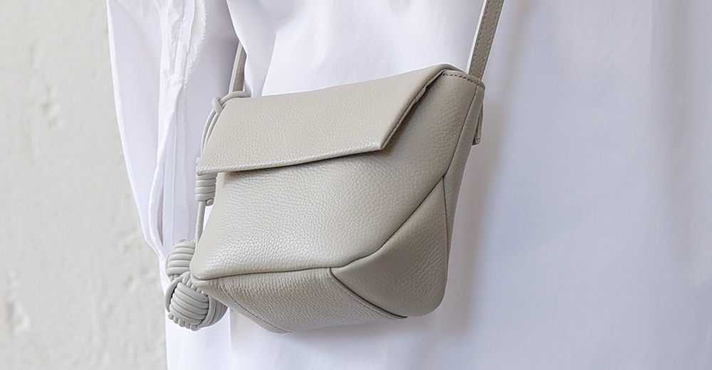 itten-itten 品牌 Neru 義大利皮革點結吊飾迷你單肩包，採用柔軟皮革材質，搭配獨特的點結吊飾設計，展現精緻工藝與時尚品味。