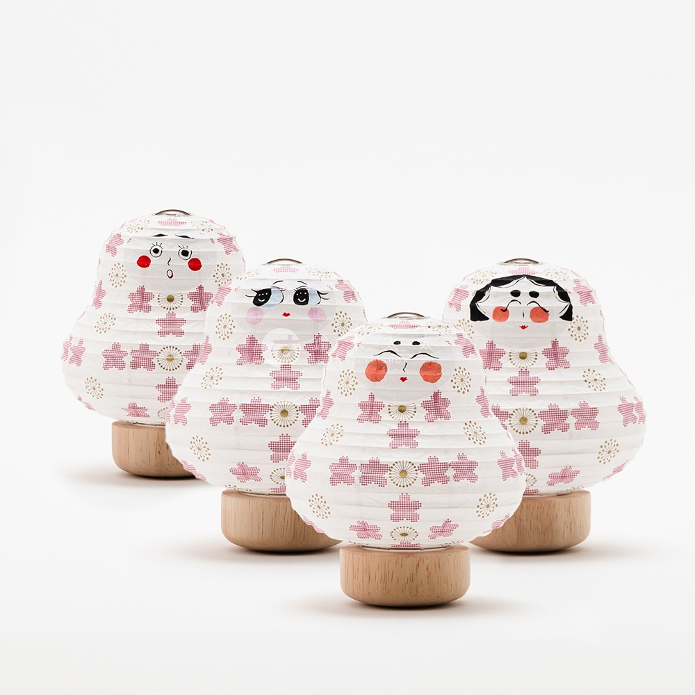 四款達摩不倒翁迷你提燈，紙質燈罩以粉色櫻花和金色圓點圖案裝飾，提燈底部為木質底座，造型可愛，風格日式。