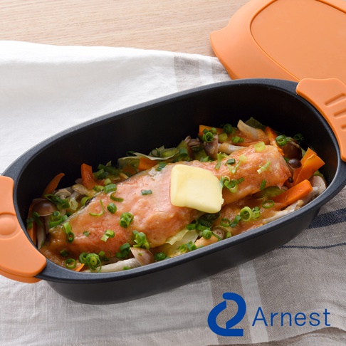 Arnest 多功能快速微波料理器中，有魚、蔬菜和一塊奶油，蓋子在旁邊