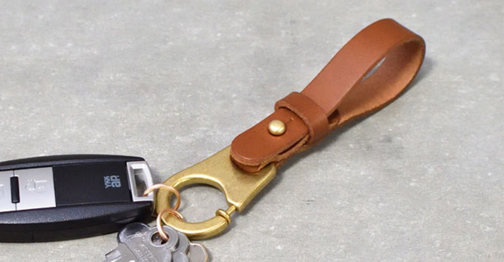 植鞣皮革鑰匙圈，附有黃銅色掛勾和鑰匙圈，皮革部分為棕色，可搭配車鑰匙使用。