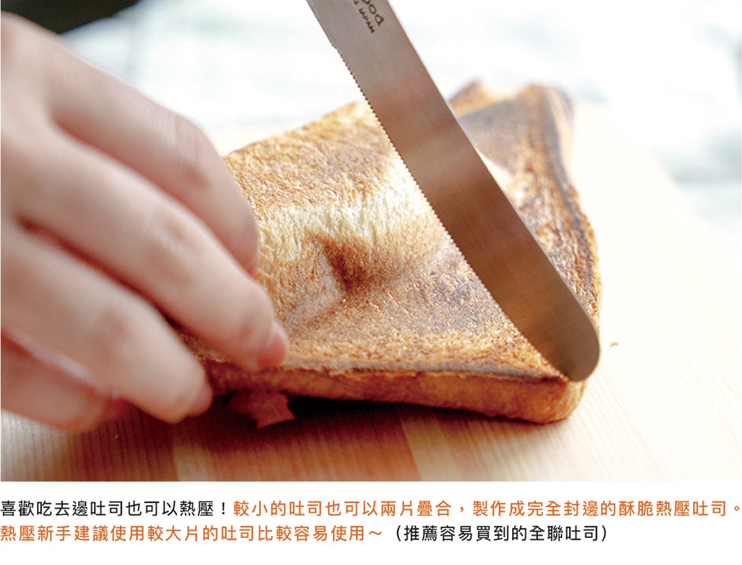 手持鋸齒刀切開金黃色烤吐司，吐司中間夾著肉餡，置於淺色木質表面上。