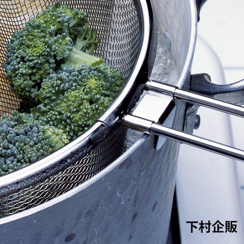 不鏽鋼可掛式料理濾網，網狀結構，裝有綠色花椰菜，濾網邊緣有兩個銀色不鏽鋼掛鉤。