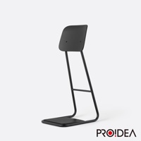 黑色 STAN CHAIR 人體工學站立椅，以金屬材質製成，椅面與椅背為一體成形設計，椅背略為傾斜，椅腳為U型結構，搭配方形止滑踏板。