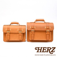 兩只棕褐色皮革製作的雙扣兩用單肩包，一大一小，均有提把、翻蓋和兩個可調節皮帶扣。