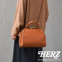 職人手作棕色皮革兩用口金手提包，簡約醫生包造型，配有頂部提把與可拆卸肩帶，金屬旋轉鎖扣，質感皮革紋理。