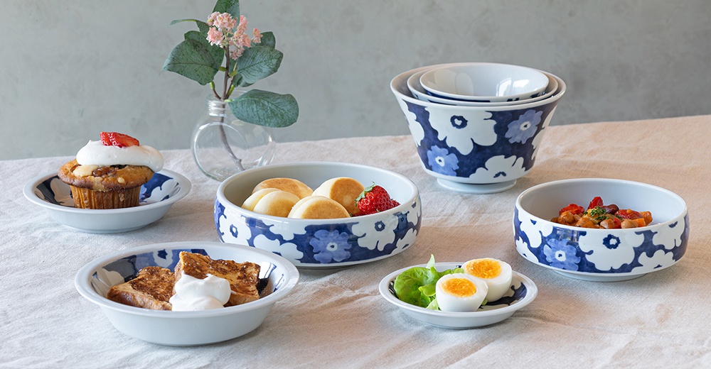 陶瓷深碟盤組，白色盤身飾有藍色花紋，呈現多種尺寸。盤中盛放著鬆餅、法式吐司、水煮蛋、沙拉及豆類料理。