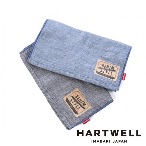 兩條今治復古丹寧風雙織柔感毛巾，一條為淺藍色，另一條為灰色。兩條毛巾均帶有「DENIM STYLE」標籤，織紋細緻，邊緣有縫線。